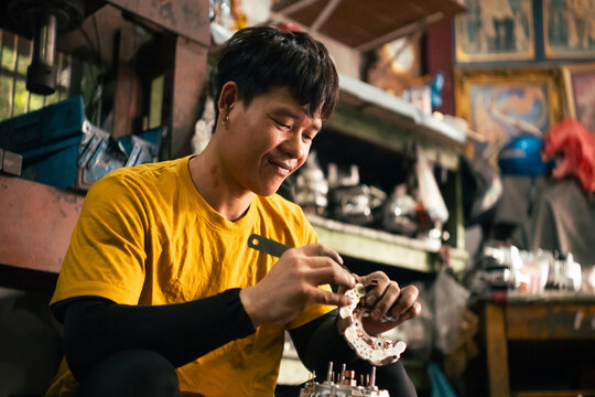 Mechanic smiling carefully assembling engine parts in workshop