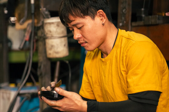 Mechanic performing meticulous engine component repair in a garage
