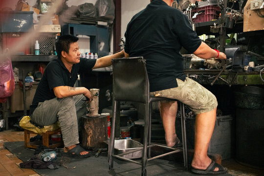 Mechanics collaborating on engine repair in workshop as a team
