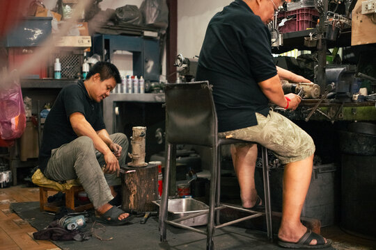 Mechanics diligently working on engine parts in a busy dirty workshop
