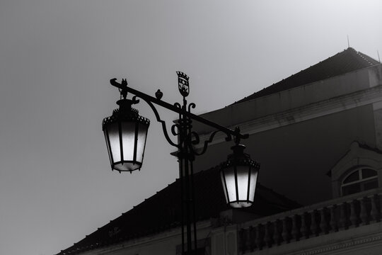 Vintage street lamps silhouetted against sky and building