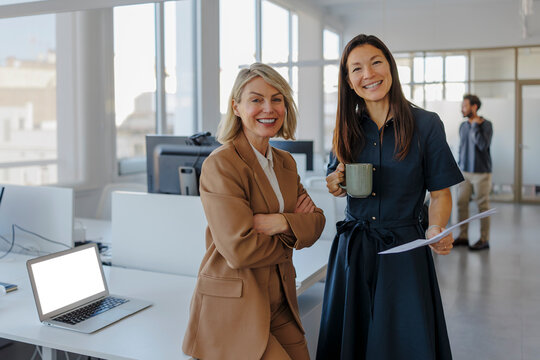 Business partners looking at camera in modern office workplace