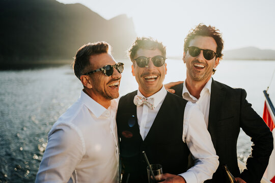 Groom laughing with best friends during relaxed boat celebration