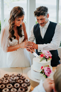 Bride and groom cutting wedding cake during intimate reception
