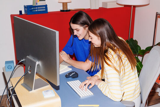 Women in business collaborating at computer in modern home office