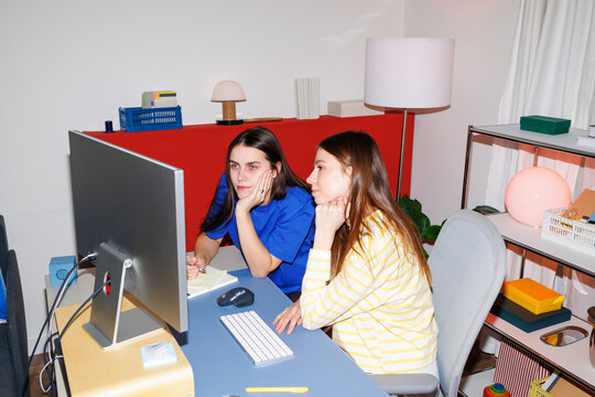 Women working together at computer in home office