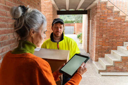 Delivery Person Hands Package to Woman in Entrance