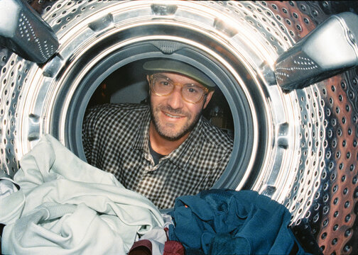 Analog portrait from inside a dryer of man looking at camera