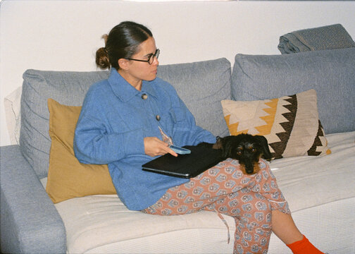 Woman spending quality time with her dachshund lying in her lap
