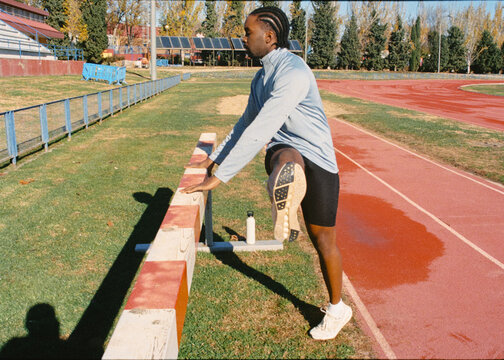 Film shot of professional athlete performing leg stretches