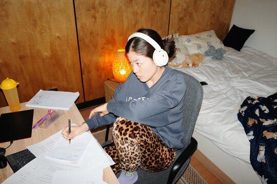 Person studying diligently for exams wearing headphones