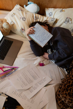 Tired individual resting while studying for exams