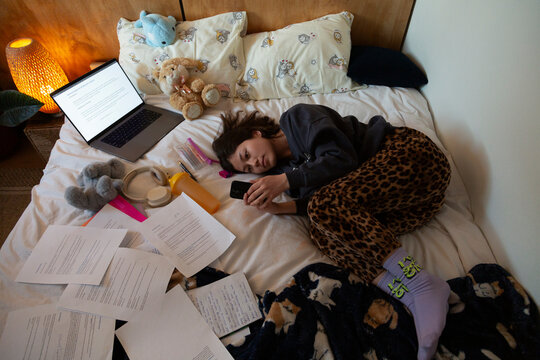 Overworked individual procrastinating studies while feeling stressed