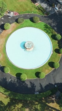 Aerial view of a circular fountain with manicured bushes and a paved walkway in a park in Marine Parade, Napier, Hawkes Bay, New Zealand.