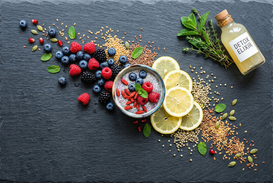Healthy detox elixir bottle with chia seed pudding and fresh scattered berries