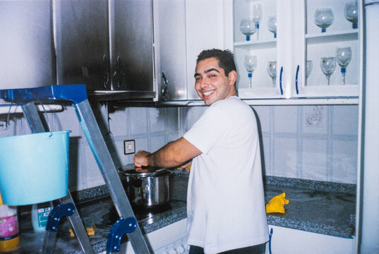 Man cleaning a burnt kitchen after a cooking accident