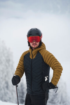 A skier standing in a snow-covered forest at a ski resort