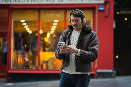 Man listens to music in city street
