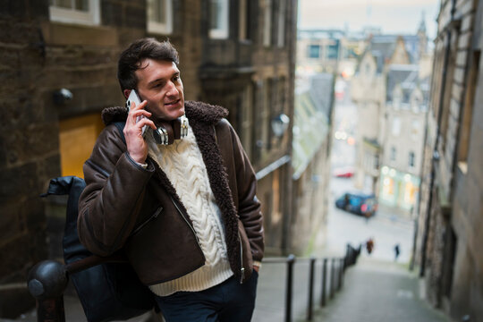 Man talking on phone in city street
