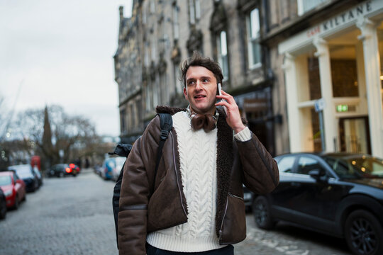 Man talking on phone in city street
