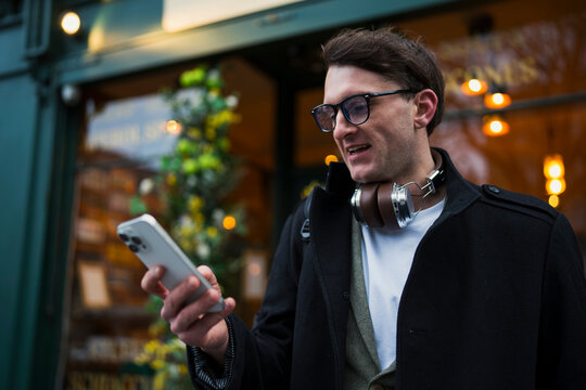 Man checks phone outside cafe
