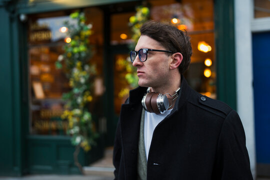 Man wearing headphones outside shop
