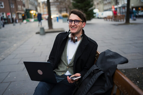 Man works on laptop in city park
