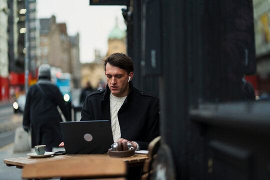 Working on a laptop outside in city
