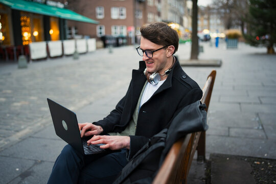 Man using laptop on street
