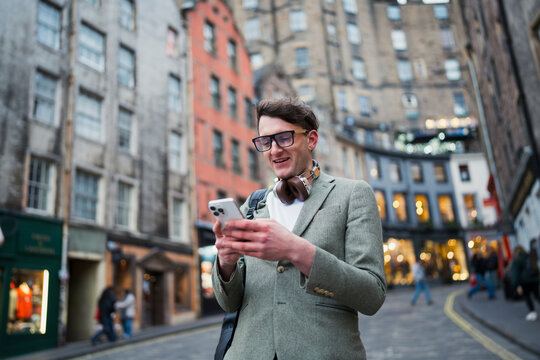 Man using phone in city street
