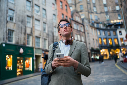 Man checks phone in Edinburgh city street
