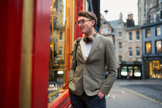 Man observing shop window in city
