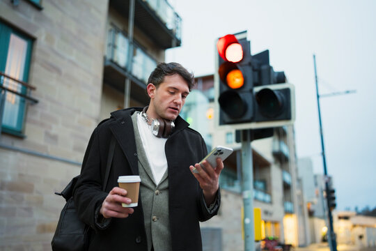 Man waits at traffic light in city
