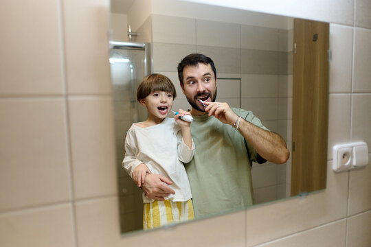 Father and son brushing teeth in morning routine