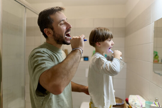 Father and son brushing teeth in morning routine