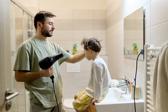 Father blow drying son&rsquo;s hair after bath