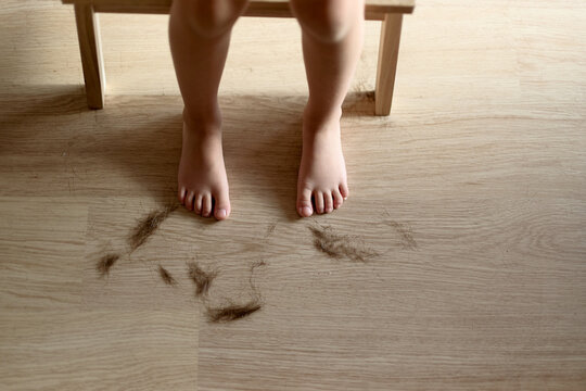 Child  standing near hair clippings on floor