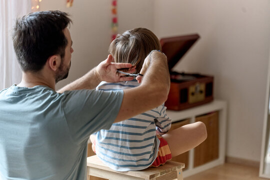 Father giving son a haircut at home