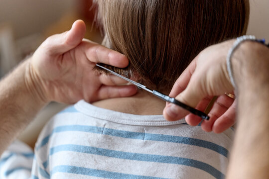 Parent trimming child&rsquo;s hair at home