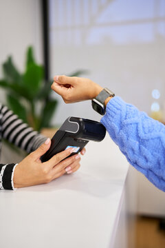 Customer making contactless payment with smartwatch in beauty salon
