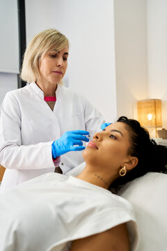 Cosmetic professional injecting woman's face