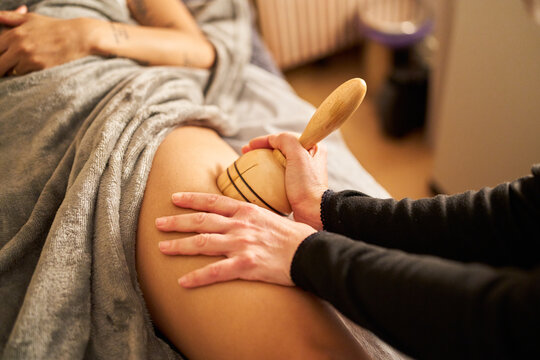 Woman receiving maderotherapy anti cellulite massage on leg