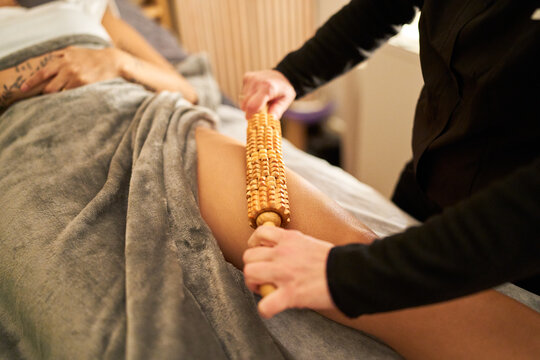 Woman receiving maderotherapy massage with wooden roller