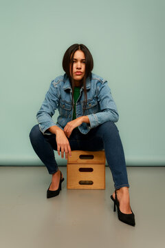 Model Poses in Denim Jacket on a Wooden Box 