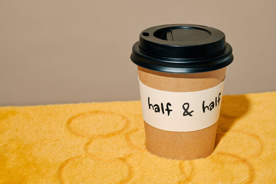 a half and half takeaway cup on yellow furry fabric