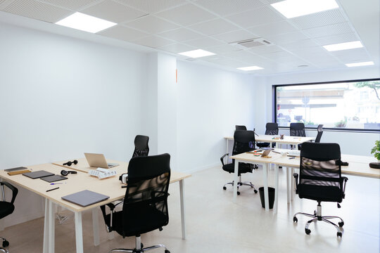 Modern coworking office space with empty desks and ergonomic chairs