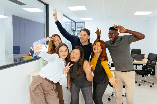 Diverse colleagues taking a fun selfie in office