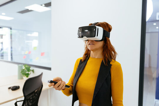 Woman experiencing virtual reality in modern office environment