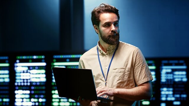 Specialist upgrading server room security to protect information access, making sure virus protection software is up to date and hackers trying to penetrate systems are rebuffed