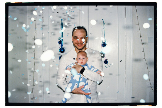 Father holds baby during celebration in a room